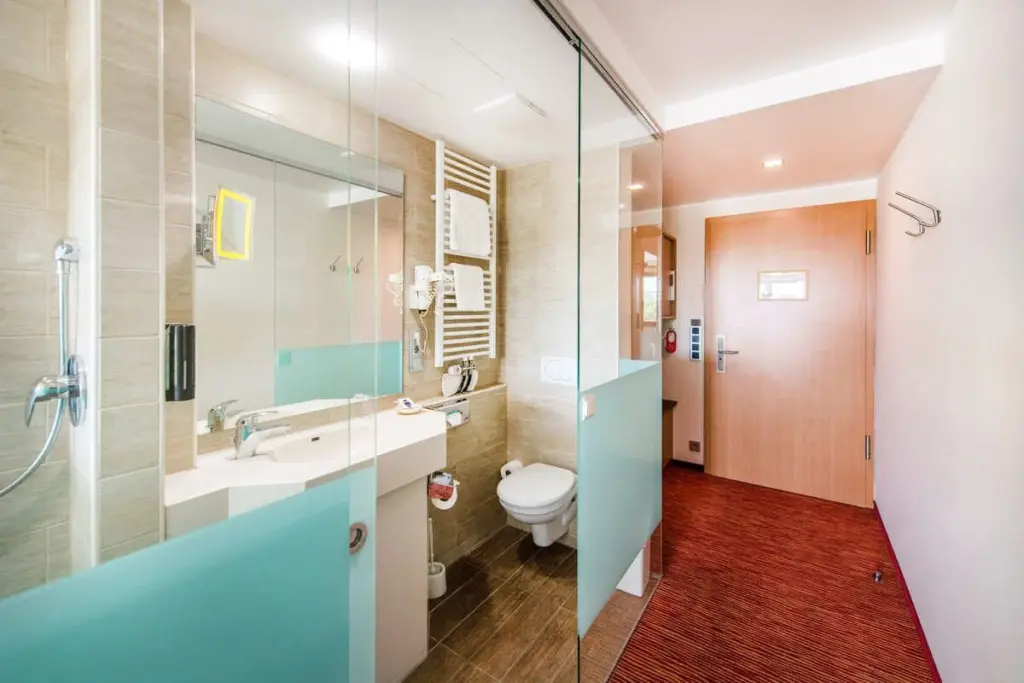 Elegantes Hotelzimmer mit rötlichen Farbtönen, modernem Design und komfortabler Ausstattung.